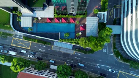 aerial drone landscape of resort pool courtyard in busy main street road with traffic transport cars driving farrer park singapore asia travel tourism