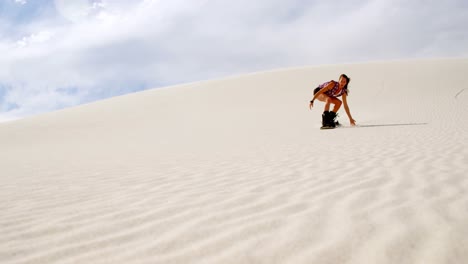 Woman-sand-boarding-on-the-slope-in-desert-4k