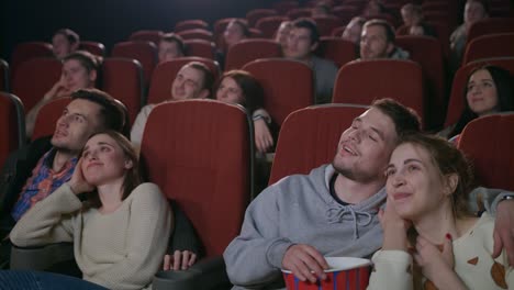 love couples watching movie at movie theater. young people eating popcorn