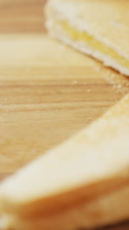 video de rebanadas de sándwiches de pan blanco con queso tostado en el fondo de la tabla de cortar de madera