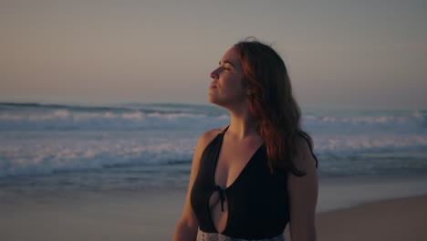 girl-slowly-walking-by-the-sea-at-golden-hour-looking-at-the-sunset-front-medium-shot