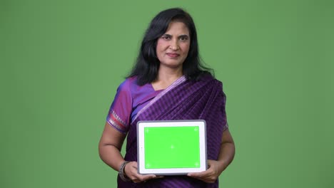 mature beautiful indian woman showing digital tablet