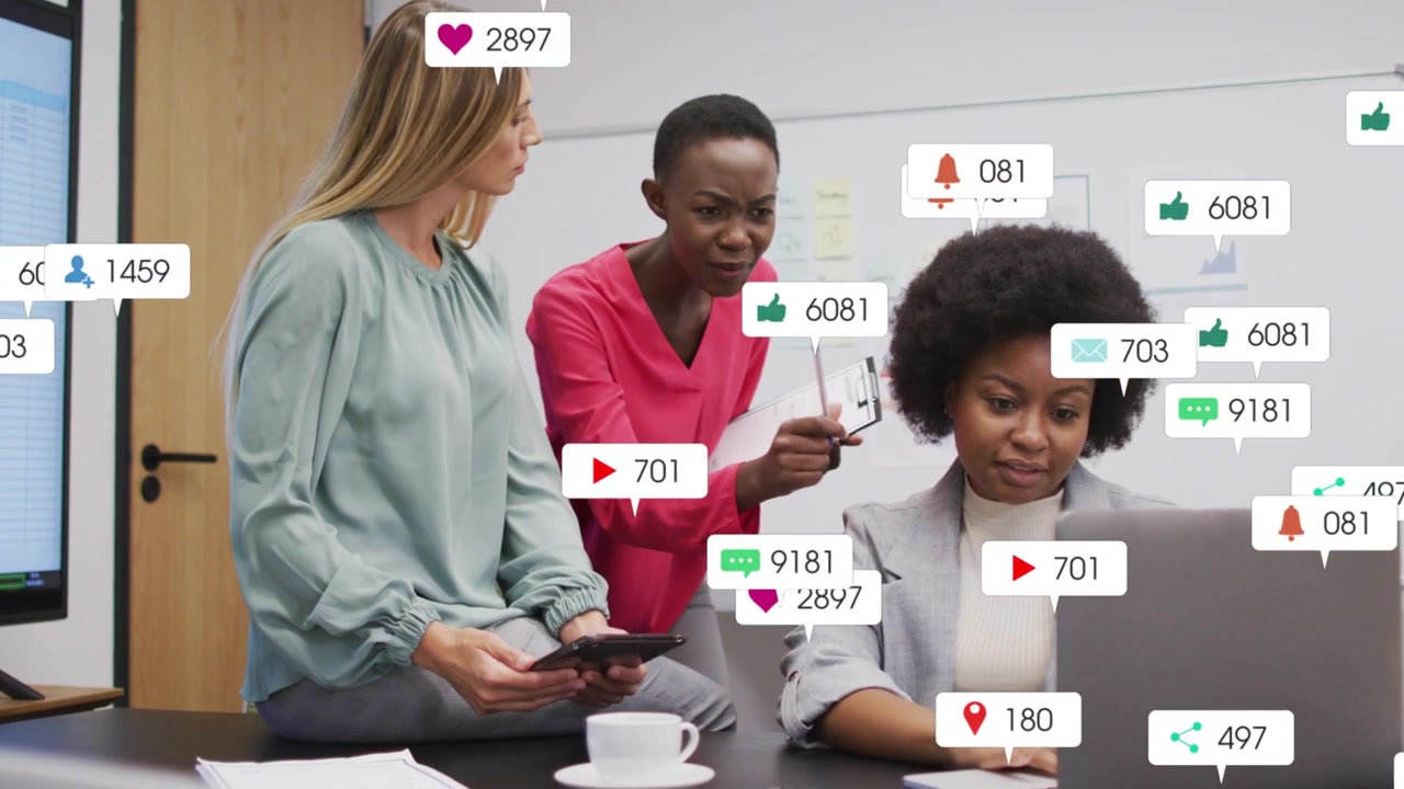 Center woman pointing at laptop, women reviewing social media metrics while animated likes growing