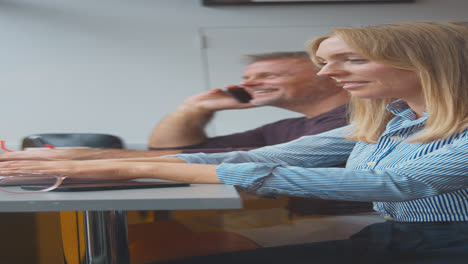 Vertical-Video-Of-Customers-In-Coffee-Shop-Window-Working-On-Laptops-And-Making-Call-On-Mobile-Phone