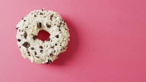 video of donut with icing on pink background