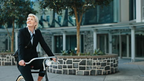 businesswoman, happy and riding a bicycle to work
