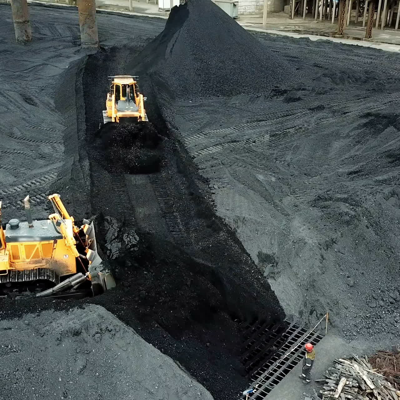 Crawler bulldozer works on coal mines. Extractive industry, anthracite. Aerial view.