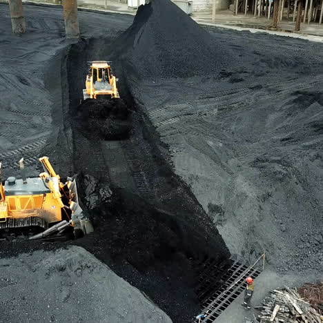 crawler bulldozer works on coal mines. extractive industry, anthracite. aerial view.