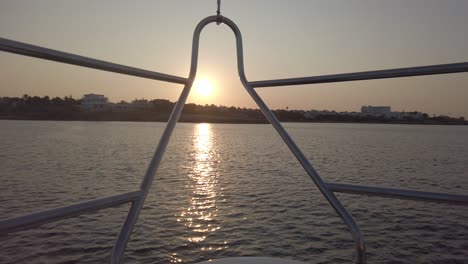 wunderschöner mediterraner sonnenuntergang über dem land, gesehen von der vorderseite einer yacht, die landeinwärts segelt