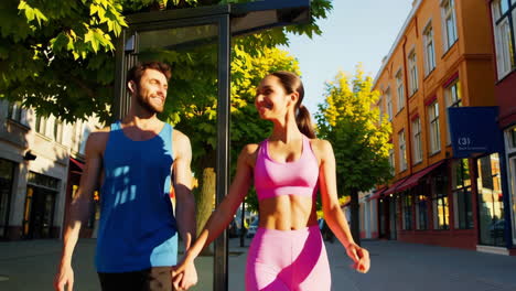 happy couple walking hand in hand on a sunny city street