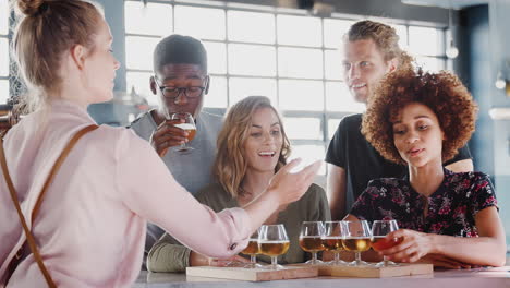 serveerster die een groep vrienden bedient bij het proeven van bier in een bar