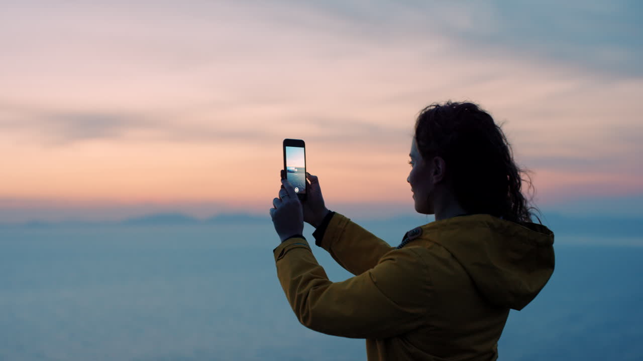 Woman Taking Pictures of Sunrise over Mountains
