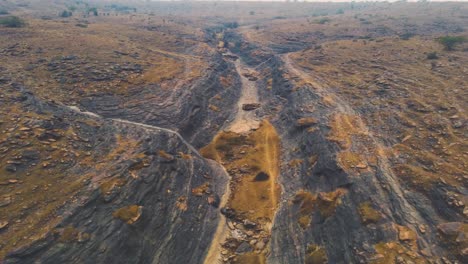 vuelo cinematográfico de drones aéreos sobre un barranco seco en un paisaje árido condiciones de sequía debido al calentamiento global y el cambio climático