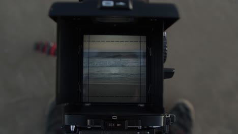 olas rompiendo en la playa a través del visor de una cámara de cine