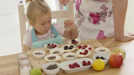 Child-and-woman-preparing-muffins-on-table