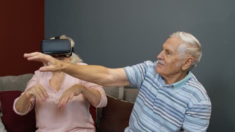 grandfather and grandmother with vr headset helmet play games, watch virtual reality 3d 360 video