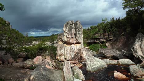 ujęcie 4k fajnej formacji skalnej pośrodku małej rzeki, która prowadzi do wodospadu devil's pit w słynnym parku narodowym chapada diamantina w północno-wschodniej brazylii w pochmurny deszczowy dzień