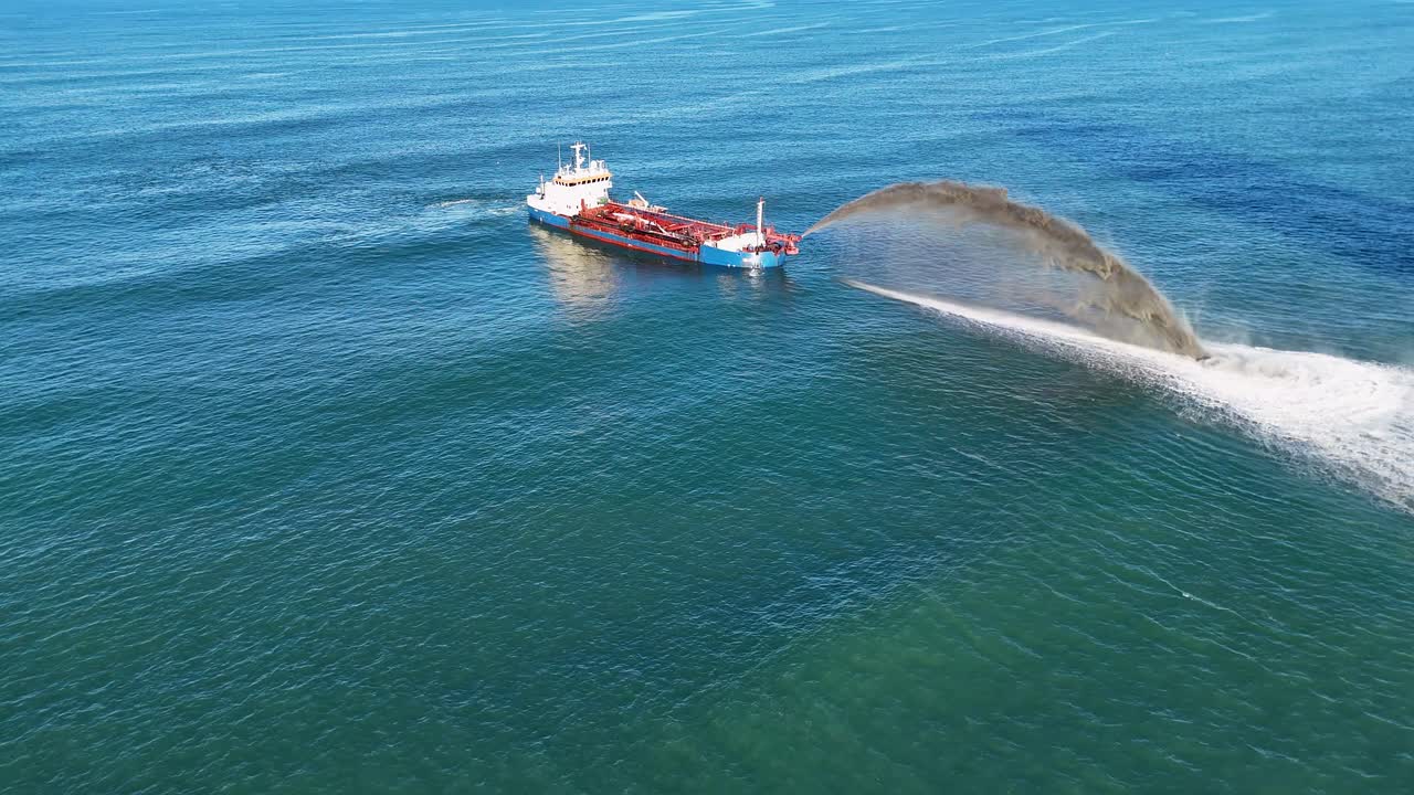 Aerial view of a dredging ship pumping sand to restore beach erosion on the Gold Coast, Australia, under clear blue skies