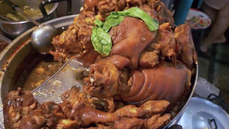 thai style seasoned cooked pork elbow feet in pot ready to serve