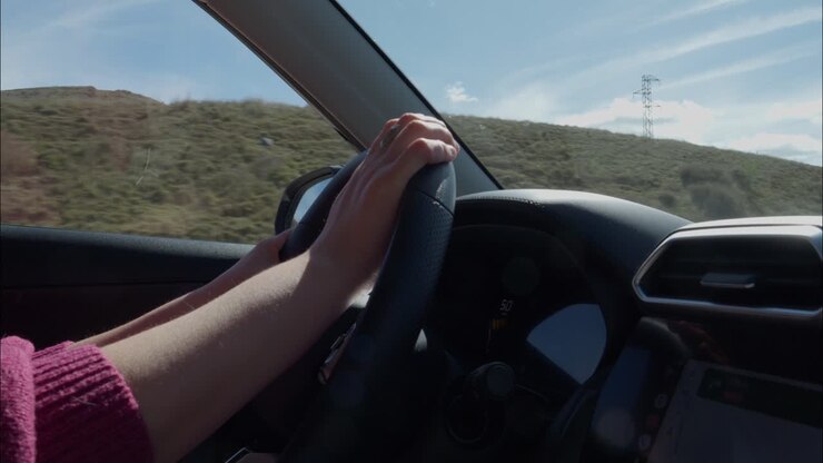 Primo piano delle mani sul volante mentre si guida l'auto