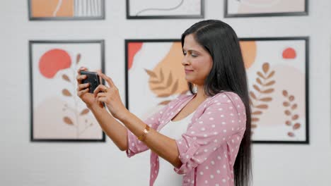 Modern-Indian-woman-watching-video-on-phone