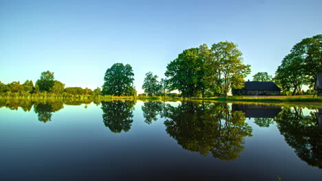 timelapse captures the beauty of a rural landscape with a tranquil lake and house as it transitions through the four seasons with snow, autumn leaves and frozen lake
