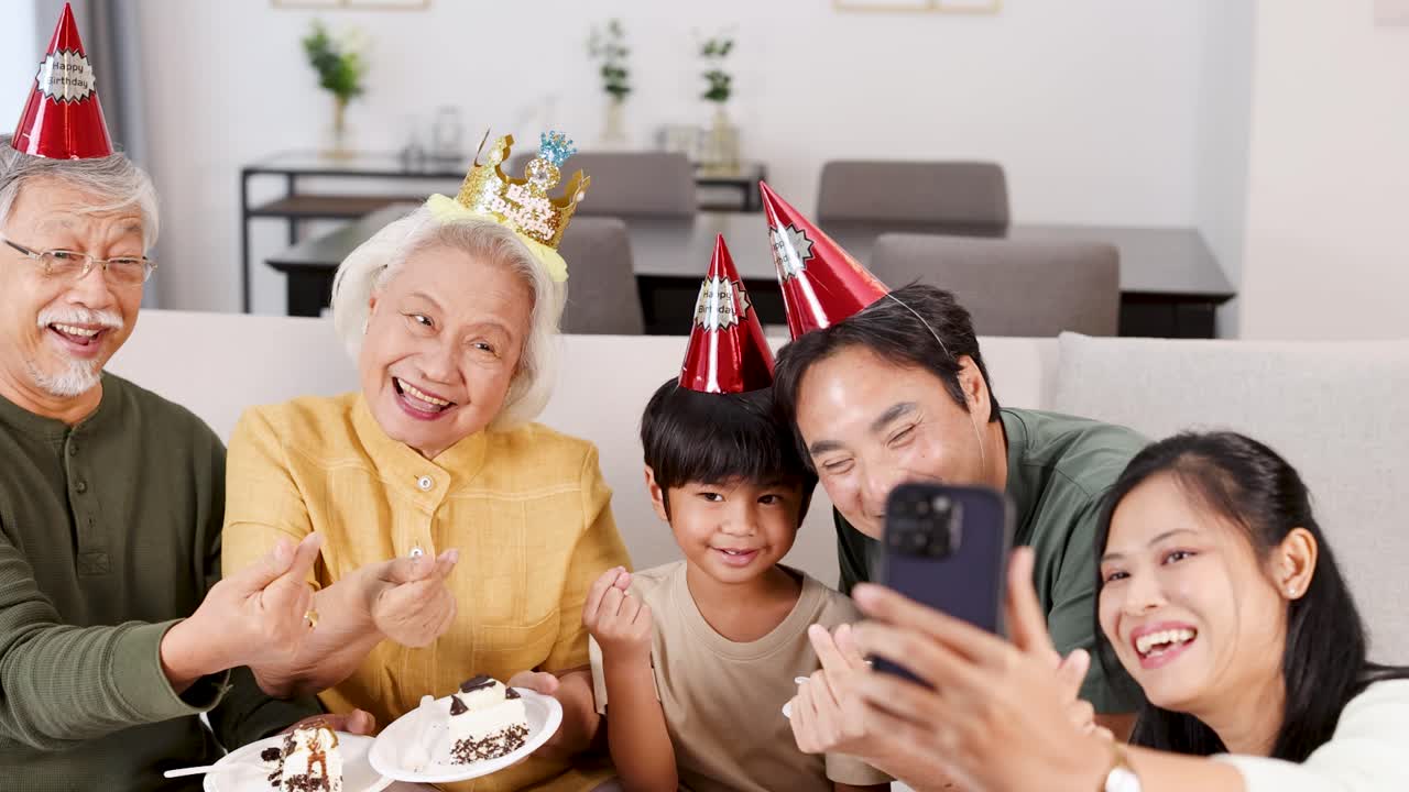 A joyful family captures a birthday celebration with cake and selfies, creating cherished memories in a warm, well-lit setting