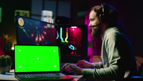 Chroma-Key-Laptop-Neben-Einem-Mann,-Der-Ein-Einzelspieler-Videospiel-Mit-Hoher-FPS-Und-Raumschiff-Schusslasern-Spielt