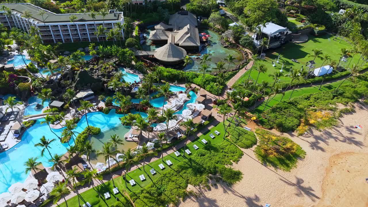 Grand Wailea resort swimming pools and sandy beach in Wailea, Maui, aerial orbit shot