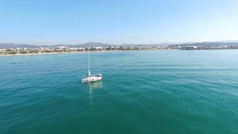 barco de vela con un pueblo mediterráneo