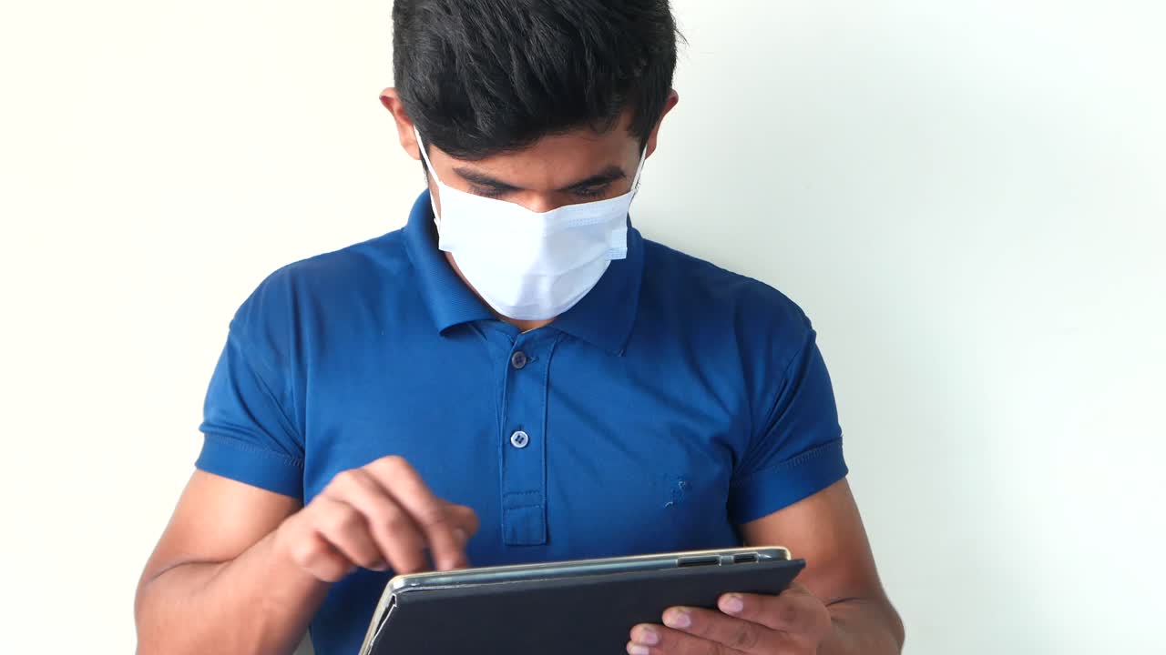 hombre usando una tableta con una máscara