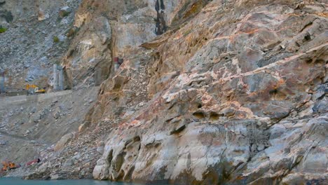 construction work on rock stone mountains with lake, close up view of mountains