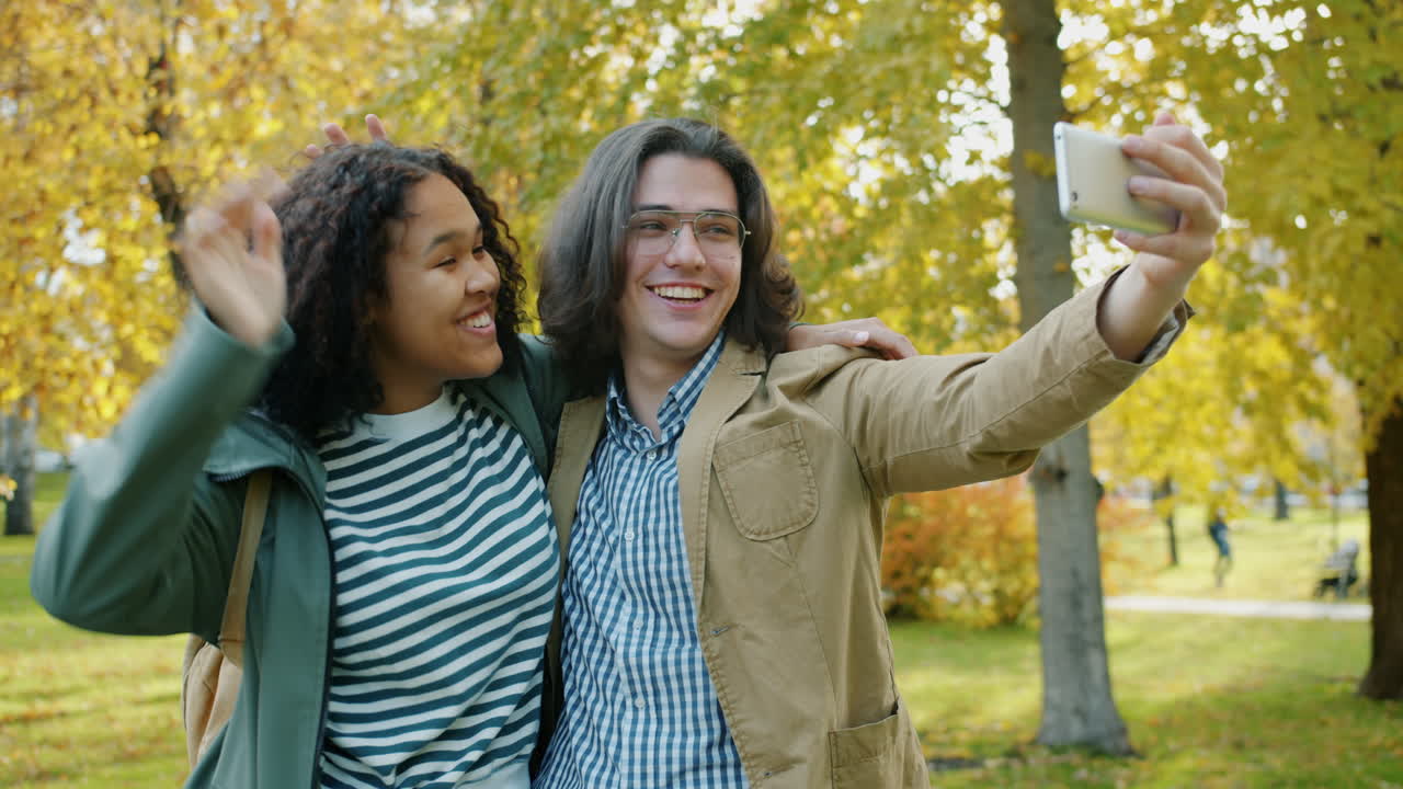 Happy Couple Taking a Selfie in an Autumn Park