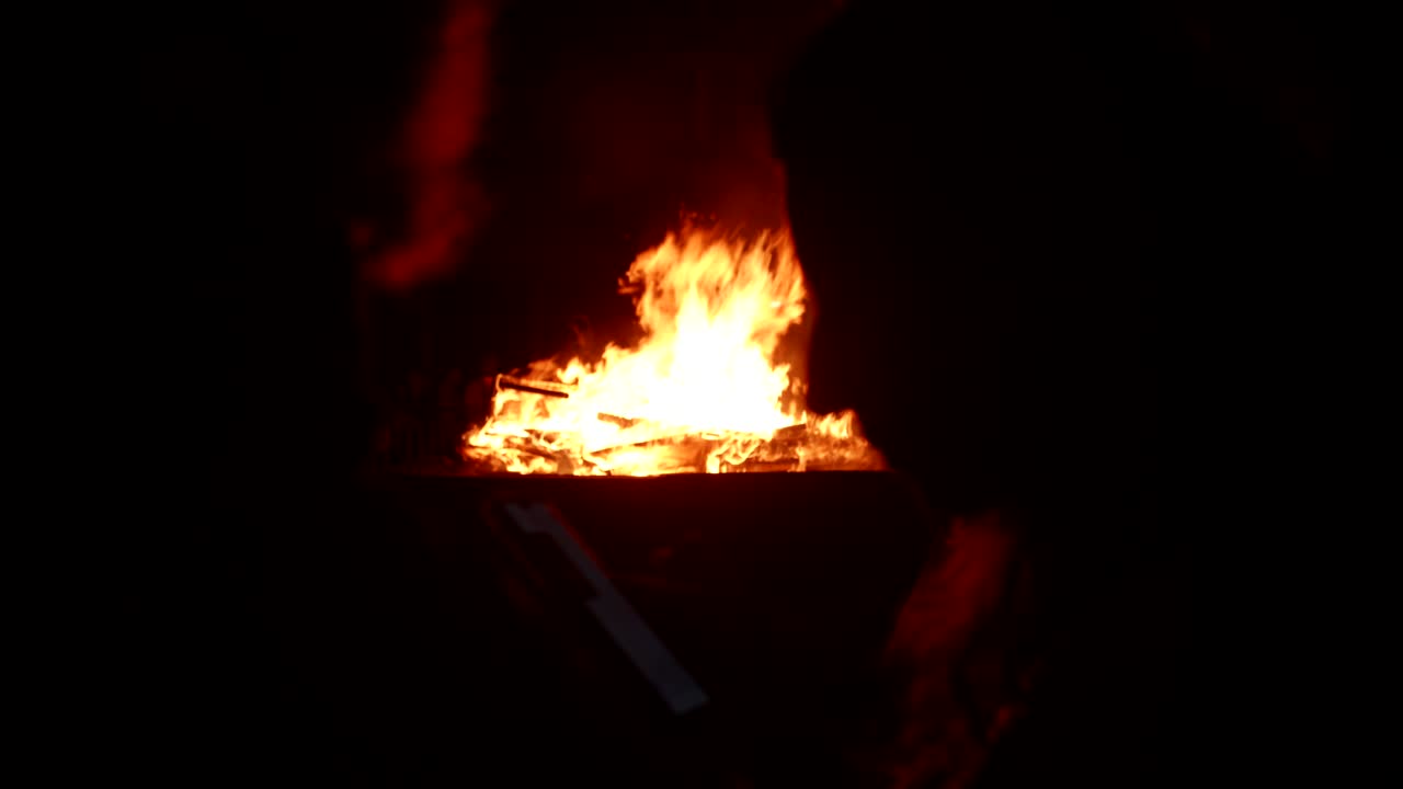 Large Bonfire Burning Brightly with Flames and Smoke at Night