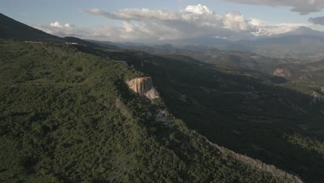 Sunset-golden-hour-aerial-of-giant-calcite-rock-formation-in-mountains