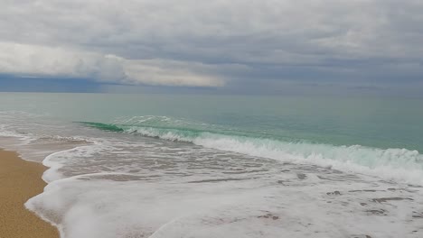 Grober-Sandstrand-Meereswelle-In-Zeitlupe-Bei-120fps-4k-Bewölkter-Tag-Türkisfarbenes-Wasser-Einzelne-Meereswellen-Großer-Leerer-Strand