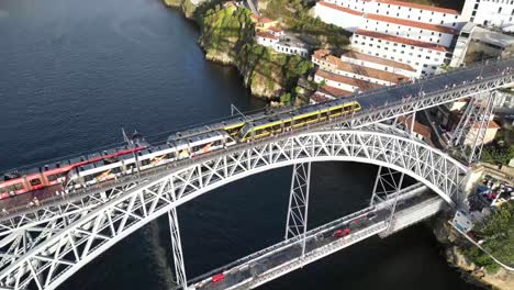 Toma-De-Drones-De-Trenes-Cruzándose-En-El-Puente-En-Porto-Portugal-Al-Atardecer