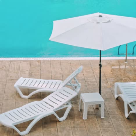 hermoso paraguas de lujo y silla alrededor de la piscina al aire libre