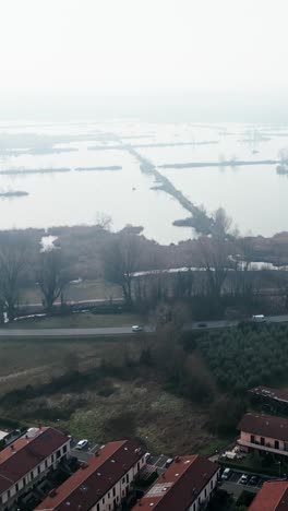 Foggy landscape with lake, buildings and road