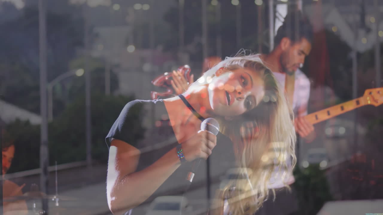 Lead singer leaning into microphone on music stage with bandmates drumming and animated sound waves