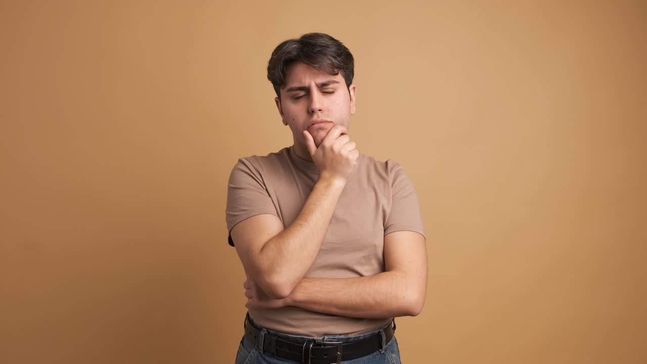 Doubtful man standing hand on chin with thoughtful expression