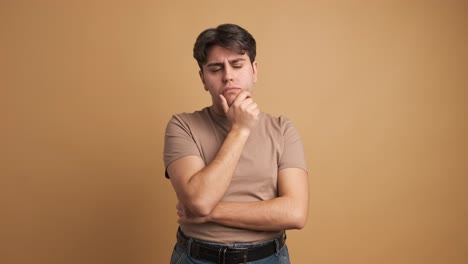 doubtful man standing hand on chin with thoughtful expression