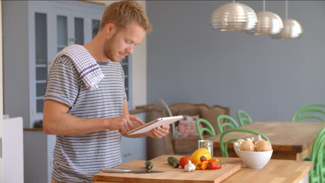 hombre sigue la receta en la tableta digital en la cocina filmado en r3d