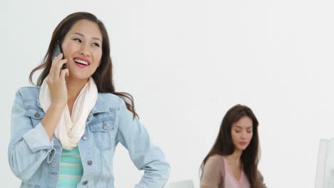 창의적인 사업가 여성이 전화로 그녀의 뒤에 동료와 함께
