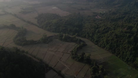 Vista-Aérea-De-Los-Campos-Agrícolas-En-Vang-Vieng,-La-Capital-De-Aventuras-De-Laos.