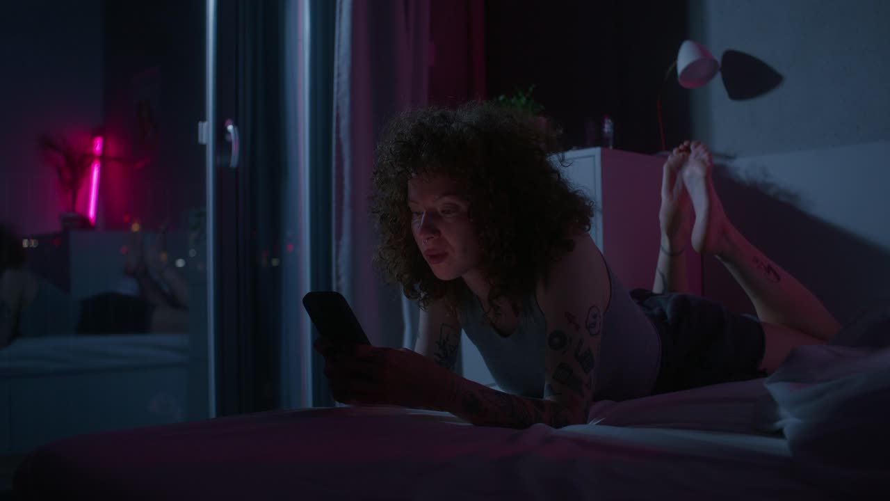 mujer usando teléfono inteligente en la cama por la noche
