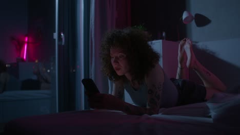 woman using smartphone in bed at night