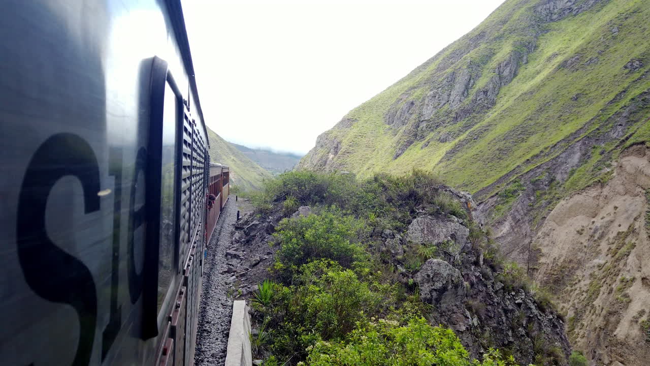 viaje en tren a través de las exuberantes montañas verdes de alausi de ecuador, cielos nublados por encima, vista lateral dinámica