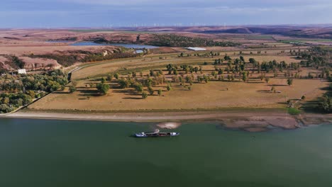 aerial wide shot of a dredger unloading dredged sand on a big river, sunny day