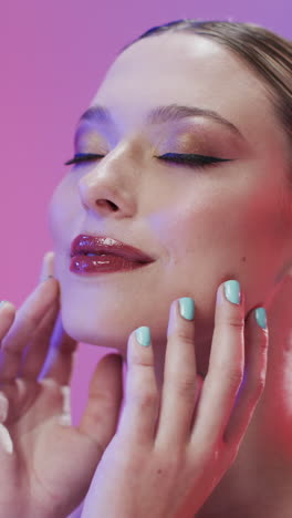 vertical video of caucasian woman with brown hair and make up touching face, copy space, slow motion
